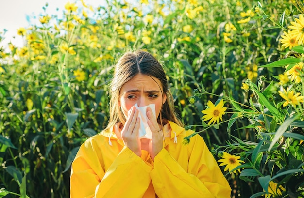 Beautiful sexy young woman lies on flowers background young girl sneezing and holding paper tissue