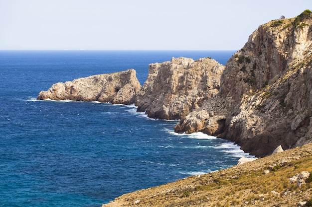 Beautiful shot of a blue ocean with a cliff partly in water - perfect for surface