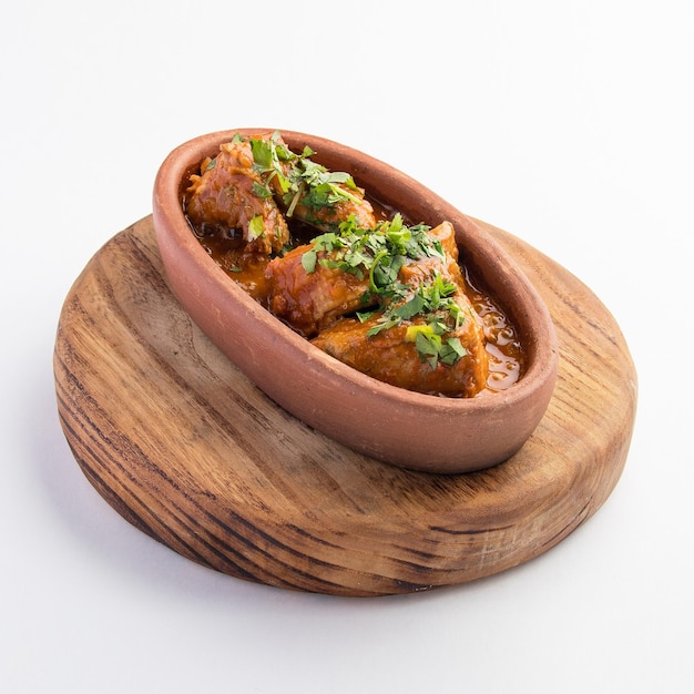 A beautiful shot of a bowl of cooked meat with curry sauce