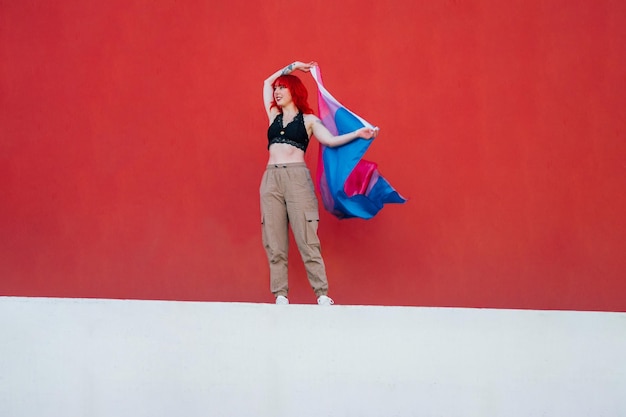 Beautiful shot of a female waving red and blue flag with a red background