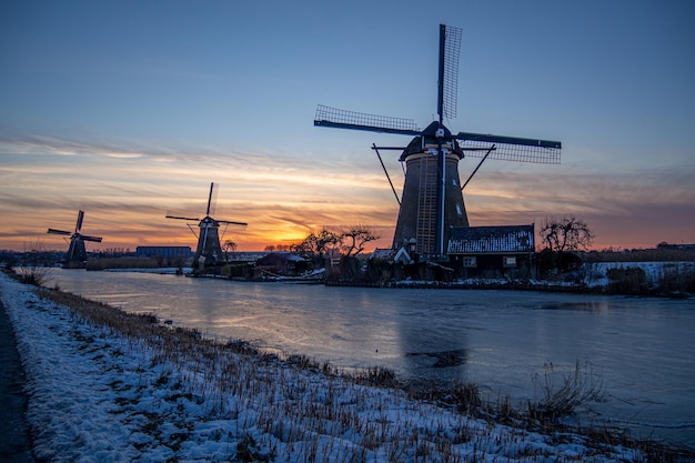 Bellissimo scatto dei mulini a vento di kinderdijk al tramonto nei paesi bassi