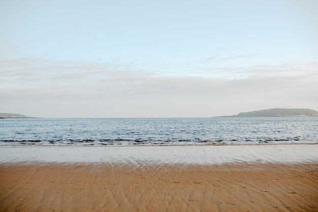 Photo beautiful shot of the new river beach with the seascape in daylight under the blue cloudy sky