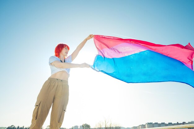 Beautiful shot of a red hair female waving blue and red flag