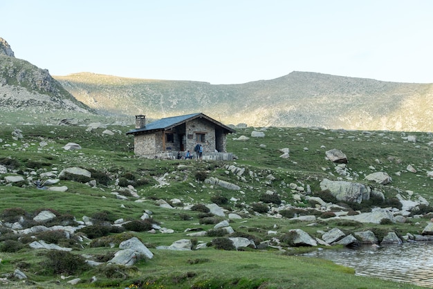 Foto bello scatto di una piccola casa in un paesaggio di montagna sotto la luce del sole