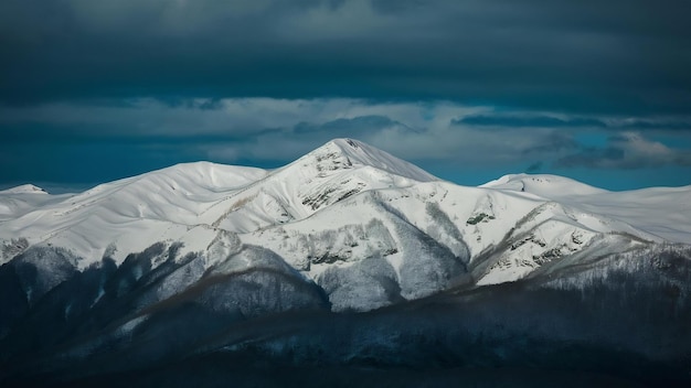 Beautiful shot of snowy mountains with a dark blue sky