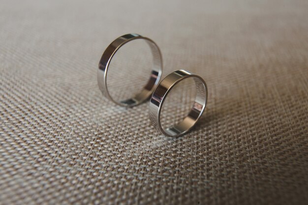 Beautiful silver wedding rings on grey fabric