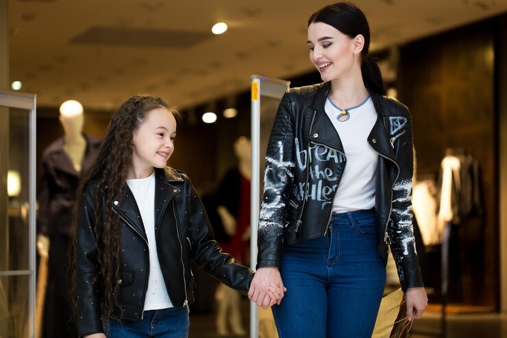 Photo beautiful sisters are holding shopping bags and smiling while doing shopping in mall