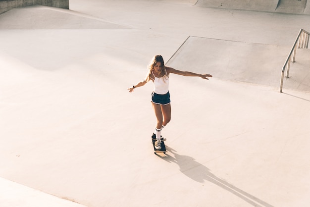 Momenti di lifestyle di bella ragazza skater in uno skatepark