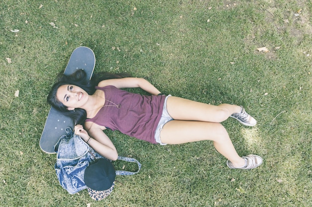 Photo beautiful skater girl relaxing at park, top view