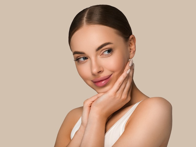 Beautiful skin face woman natural make up healthy skin touching her face. Color background. Brown