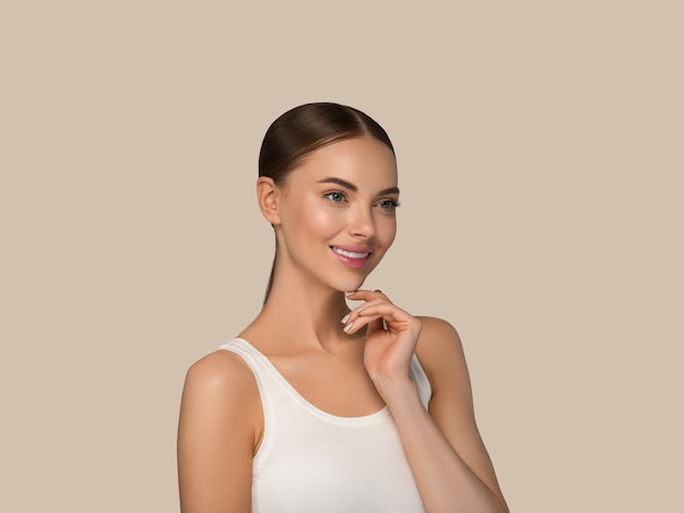 Beautiful skin face woman natural make up healthy skin touching her face. Color background. Brown