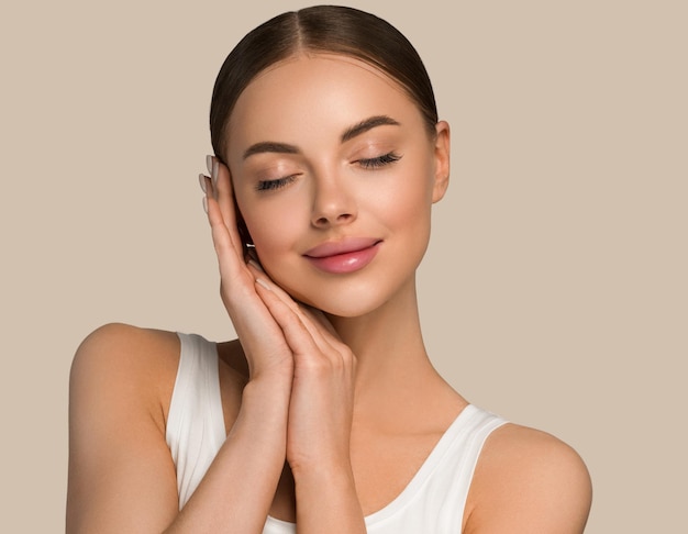 Beautiful skin face woman natural make up healthy skin touching her face. Color background. Brown