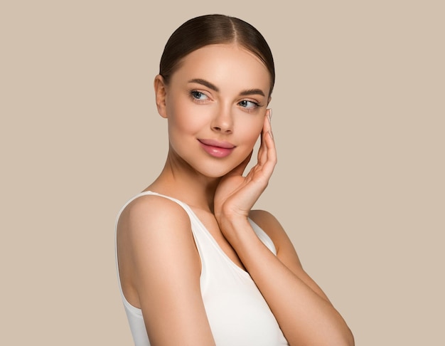 Beautiful skin face woman natural make up healthy skin touching her face. Color background. Brown