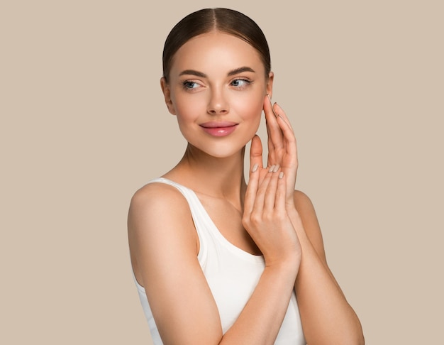 Beautiful skin face woman natural make up healthy skin touching her face. Color background. Brown