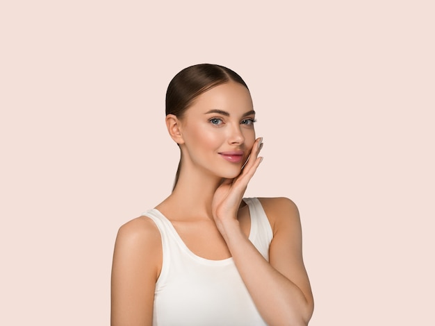 Beautiful skin face woman natural make up healthy skin touching her face. Color background. Yellow