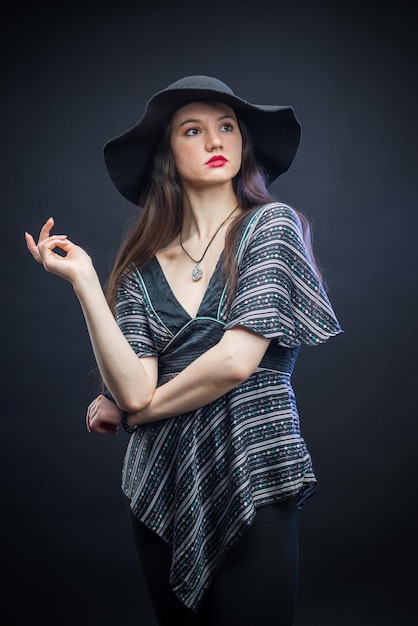 Beautiful slender girl posing in a dark studio