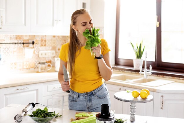 Photo a beautiful slender woman is slicing vegetables in the kitchen