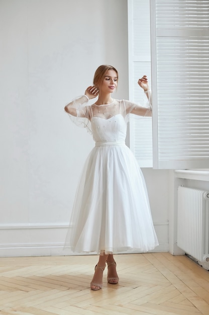 Beautiful slender woman in white wedding dress, new collection of dresses for the bride. Noise, out of focus