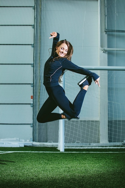 Beautiful slender young woman in sportswear is engaged in the sports stadium