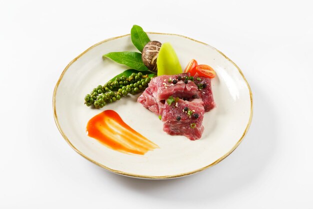 Beautiful slices of meat arranged in a plate. There are many kinds of vegetables arranged beautifull