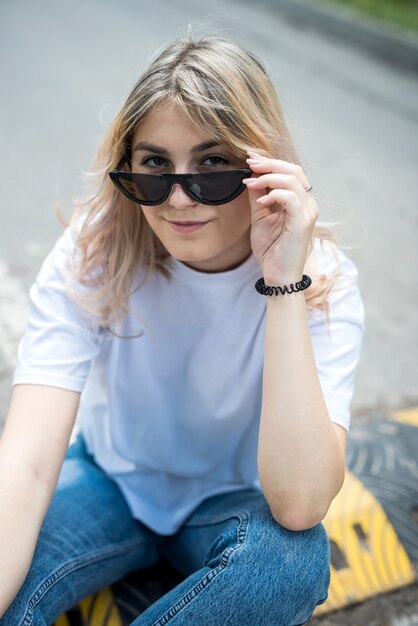 Photo beautiful slim girl with wearing casual cloth sitting on the road in the woods, summer day. outdoors