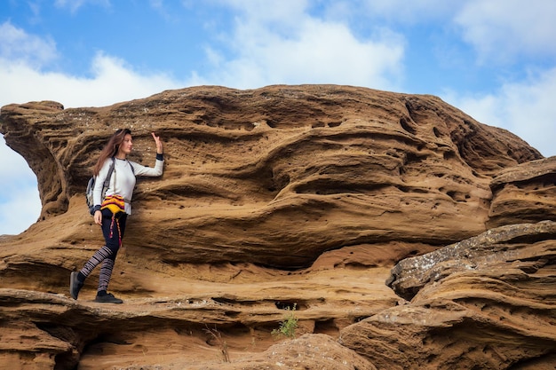 바위 협곡 돌 하늘 배경에 큰 암벽 등반을 등반 하는 아름 다운 슬림 하 고 스포티 한 젊은 관광 여자