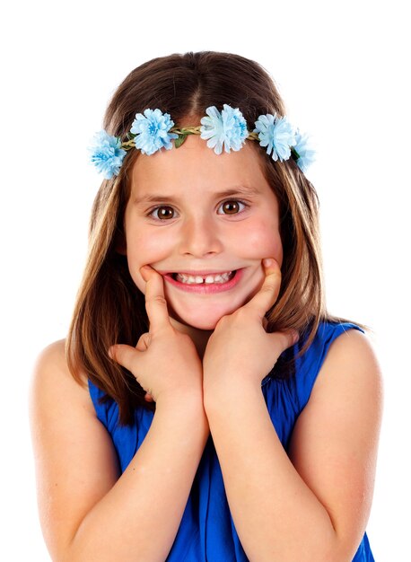 Foto bella piccola ragazza con abito blu e una corona di fiori sulla sua testa che mostra il sorriso