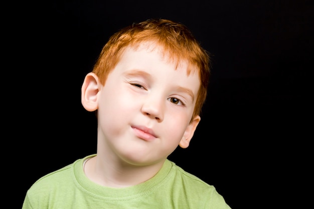 A beautiful smart boy winks an eye a closeup portrait