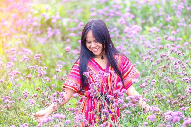 Beautiful smile asian women in flowers verbena bonariensis garden at Monjam, Chiang Mai, Thailand