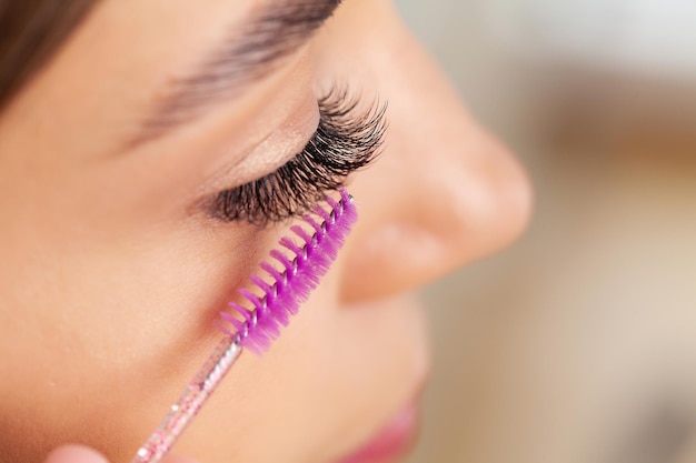 Photo beautiful smile young woman doing make up in her bathroom