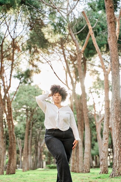 Beautiful smiling african american woman touching her curly hairstyle