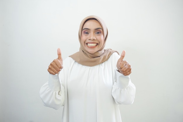 Beautiful smiling Asian woman thumbs up gesture with hand isolated over white background