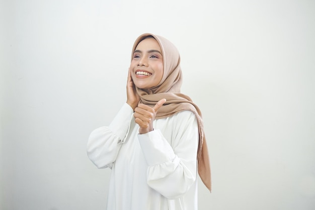 Beautiful smiling Asian woman in white casual showing thumbs up gesture with hand