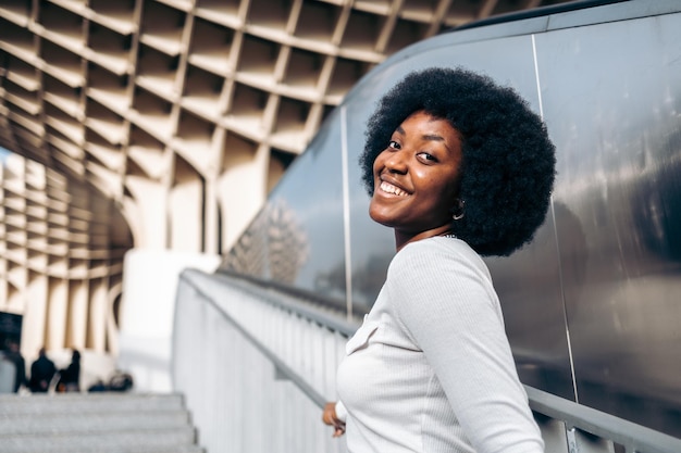 Beautiful smiling black teenage girl turning to camera on stairway