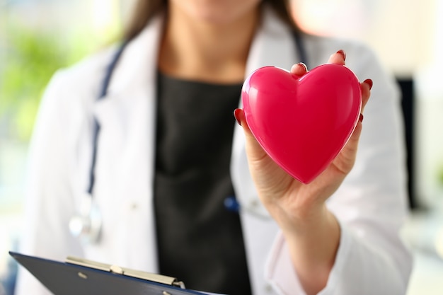 Bella tenuta femminile bionda sorridente del medico