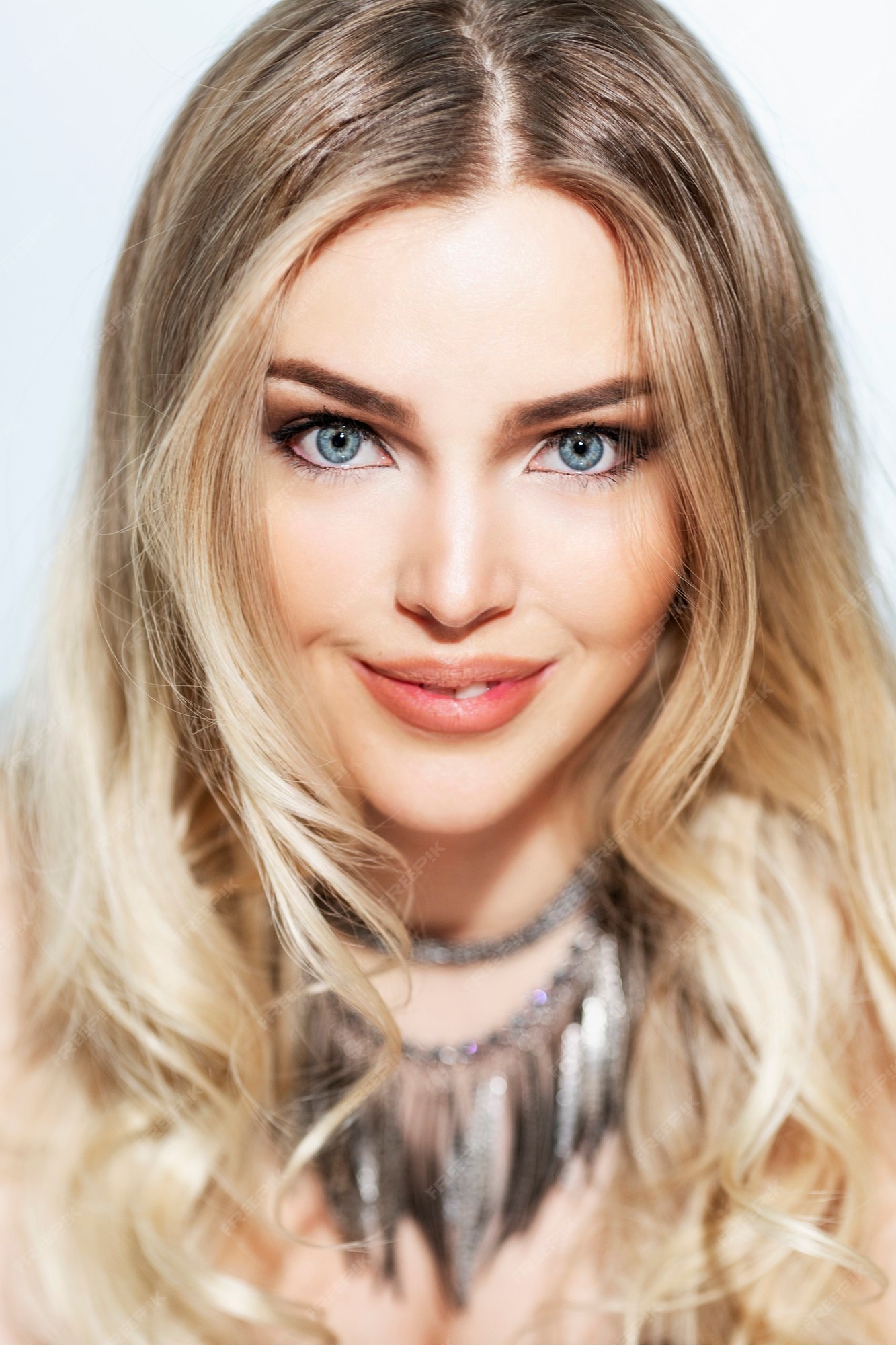 Premium Photo | A beautiful smiling blonde with bright blue eyes and long  luxurious hair. an elegant, showy lady. white background. close-up.  vertical.