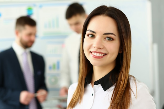 Bella ragazza sorridente dell'impiegato del brunette nel luogo di lavoro