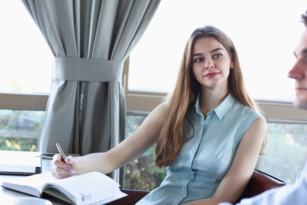 Bella ragazza allegra sorridente sul posto di lavoro