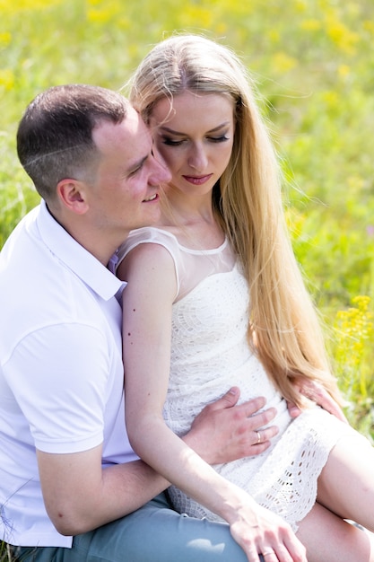 Beautiful smiling couple man woman in love. Husband and wife hugging in park on summer day.