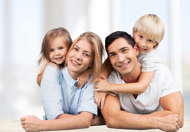 Beautiful smiling family sitting at home on background