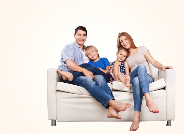 Beautiful smiling family sitting at sofa on background