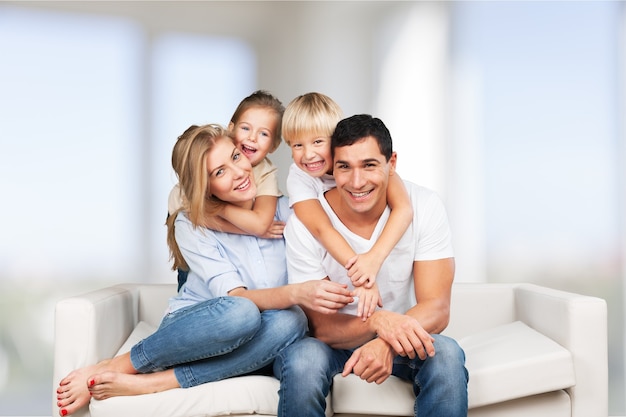 Beautiful smiling family sitting at sofa at home