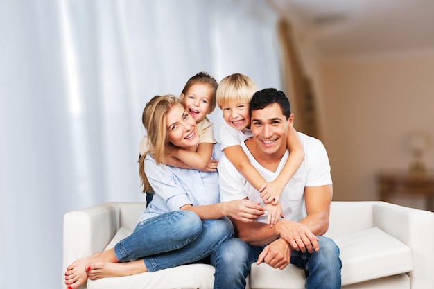 Beautiful smiling family sitting at sofa at