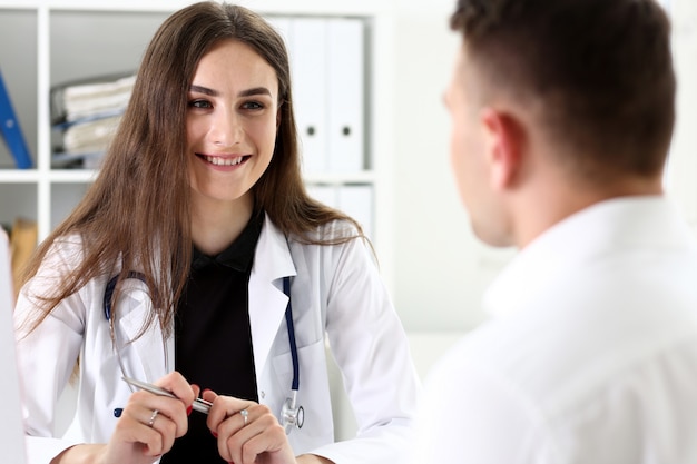 Beautiful smiling female doctor hold silver pen