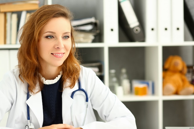 Beautiful smiling female doctor stand in office portrait