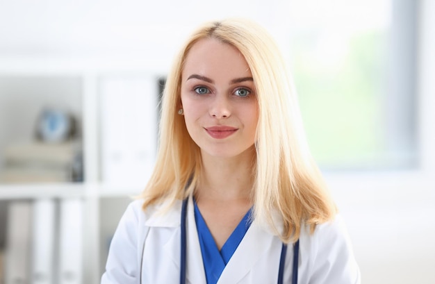 Beautiful smiling female doctor stand in office