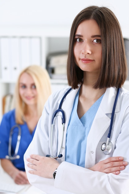 Beautiful smiling female doctor stand in office