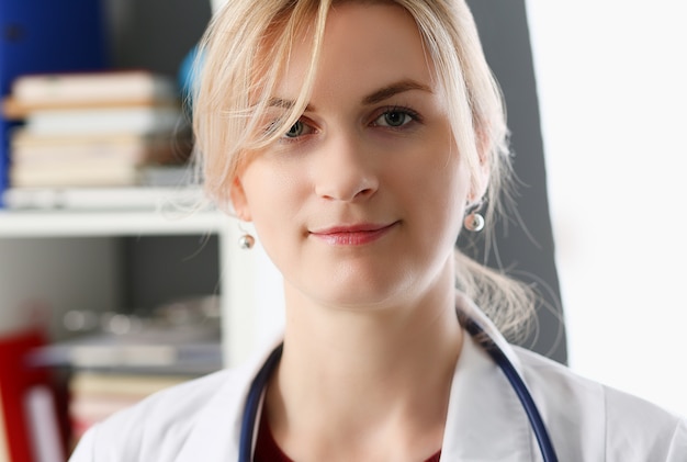 Beautiful smiling female doctor at workplace portrait