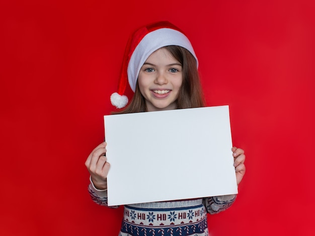 写真 新年とクリスマスのサンタクロース帽子広告コンセプトの美しい笑顔の女の子