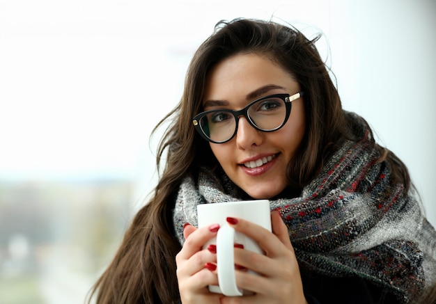 Beautiful smiling girl in a scarf portrait hold in arms big cup portrait